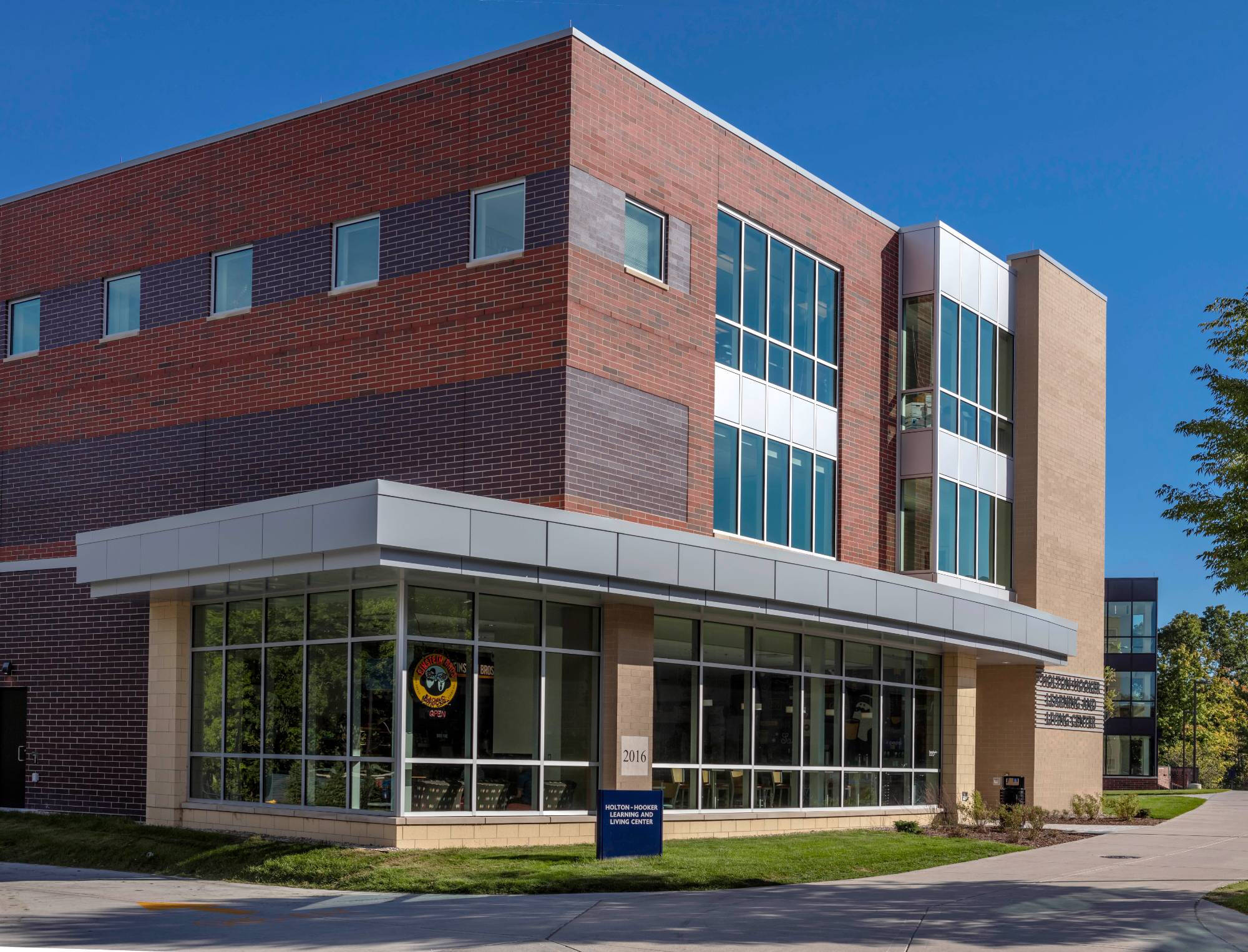 Holton-Hooker Living and Learning Center is a brick building, surrounded by trees and a sidewalk along its side.